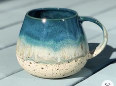 a blue and white mug sitting on top of a wooden table