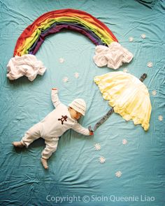 a baby doll laying on top of a bed next to an umbrella