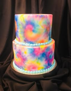 a multi - colored cake with blue beads on top