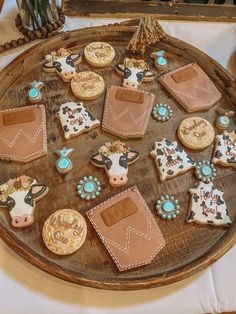 decorated cookies are arranged on a wooden platter