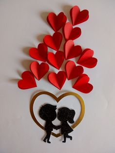 there is a paper cut out of two people kissing in front of a heart shaped tree