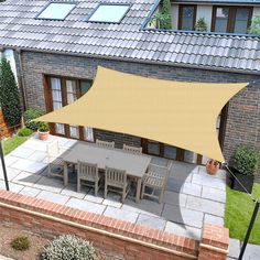 an outdoor patio area with a table and chairs under a yellow awning over it