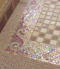 the bathroom floor is covered in colorful glass tiles