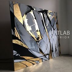 an abstract painting with gold and black colors on the wall next to a white floor