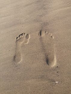 two footprints in the sand on a beach