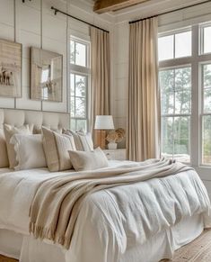 a white bed sitting in a bedroom next to two windows