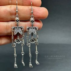 Get ready to dance the night away with these one-sided skeleton earrings in a vintage metallic silver finish! Perfect for any occasion - Halloween, Day of the Dead, a birthday party, or a night out with friends. Lightweight, articulated (all limbs are movable) and beautifully detailed, these earrings make a unique and original gift for yourself or someone special. Add some gothic, punk, and tattoo fashion to your look with these playful and quirky CALACAMANIA™ accessories Earrings details: Size: Edgy Halloween Jewelry For Costume Party, Bone Colored Metal Earrings For Pierced Ears, Punk Style Hand Cast Halloween Jewelry, Silver Metal Jewelry For Costume Party, Punk Skull Earrings For Party, Sterling Silver Jewelry For Halloween Party, Edgy Skull Earrings For Parties, Gothic Skull Earrings For Party, Edgy Adjustable Earrings For Halloween