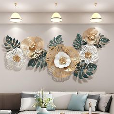 the living room is decorated with gold and white wall decor, including large metal flowers