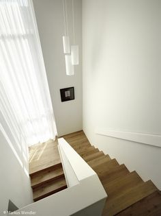 an empty room with white walls and wooden stairs