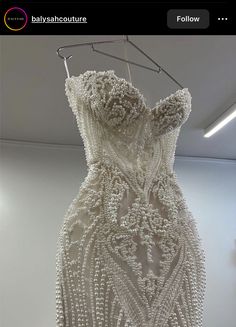 a dress made out of beads hanging from a clothes line in an office space with the words fashions universe written on it