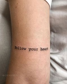 a woman's arm with the words follow your heart tattooed on her left arm