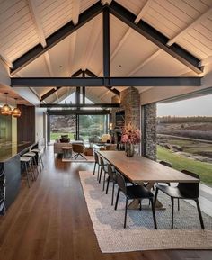 an open floor plan living room and dining area with wood floors, large windows, and wooden furniture