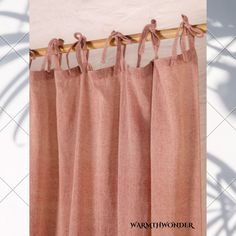 pink curtains hanging on a wooden rod