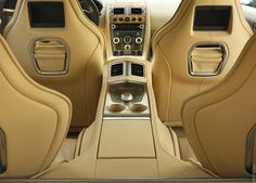 the interior of a luxury car with beige leather seats and dashboards, including steering wheel controls