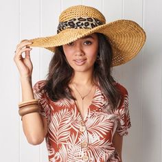 a woman in a hat poses for the camera