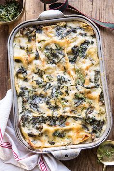 a casserole dish with spinach and cheese in it on a wooden table