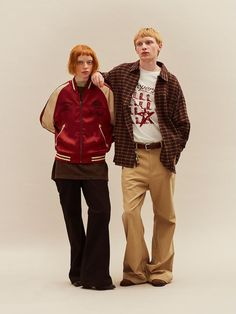 two people standing next to each other in front of a white background wearing jackets and pants