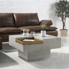 a living room with two couches and a coffee table in the middle on concrete flooring