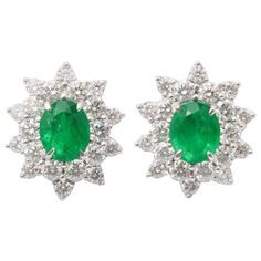 An elegant pair of certified Colombian Emerald and Diamond Earrings 4.93 carats of "VIVID GREEN" fine Colombian Emeralds 4.88 carats of round brilliant cut white diamonds. Set in 18k white gold These earrings are certified by Christian Dunaigre of Switzerland Approximately 22.5 mm x 19mm. Classic Emerald Diamond Earrings Gia Certified, Classic Gia Certified Emerald Diamond Earrings, Classic Green Diamond Earrings, Classic Gia Certified Green Diamond Earrings, Classic Green Gia Certified Diamond Earrings, Classic Green Halo Earrings, Gia Certified Green Earrings In Fine Jewelry Style, Gia Certified Green Diamond Earrings For Anniversary, Gia Certified Green Earrings Fine Jewelry