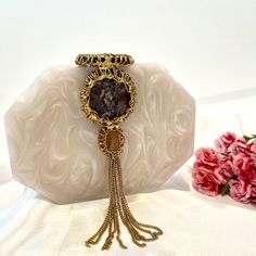 Amber – hand ctafted resin clutch in a hexagonal shape embellished with semi precious stones and finished off with a tassel to amplify her look. The perfect arm candy! Comes with a golden sling. Luxury Formal Clutch With Tassels, Gold Tasseled Clutch For Evening, Gold Evening Clutch With Tassels, Elegant Party Clutch With Latkans, Luxury Evening Jewelry With Tassels, Elegant Evening Clutch With Tassels, Gold Bohemian Clutch For Formal Events, Bohemian Gold Clutch For Formal Occasions, Formal Clutch With Tassels