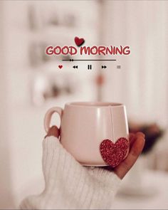 a person holding a cup with a heart on it and the words good morning above it