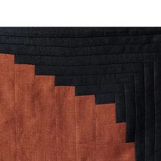 an orange and black piece of cloth is folded in rows on top of each other