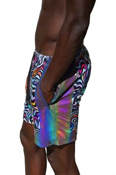 A true kaleidoscope of colors, the Psychedelic shorts are as comfy as they are stylish! Made with quality four way stretchy nylon they are quick drying and perfect for getting down on the dancefloor. The rainbow reflective panels are an added bonus and excellent for glowing in flash photography. Durable, shiny and comfortable a true triple threat! FEATURES: Made with high quality four way stretch holographic multi color neon abstract geometric print spandex Accent side panels made with rainbow r Rainy Festival Outfit, Neon Rave Outfits, Winter Rave Outfits, Winter Rave, Beach Festival Outfit, Multicolor Stretch Rave Shorts, Multicolor Moisture-wicking Shorts For Beach, Neon Rave, Multicolor Printed Pool Shorts