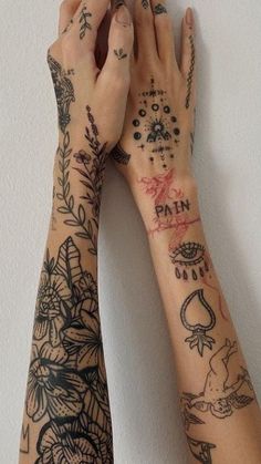 two hands holding each other with tattoos on them