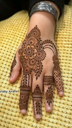 a woman's hand with hennap on it and some flowers in the middle