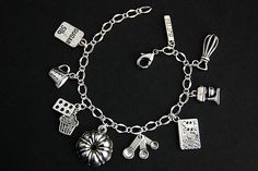 A collection of silver plated baking theme charms have been dispersed around a shimmering silver plated bracelet chain in this handmade charm bracelet. This baker charm bracelet is then completed with a lobster clasp and a 1/2 inch of chain at the end for adjustable sizing. Charms in this bracelet includes a cookbook charm, 5 lb sugar charm, cupcake charm with muffin pan charm, hand mixer charm, blender charm, measuring cup charm, measuring spoons charm, bundt cake pan charm, and stick of butter Handmade Silver Dangle Charm Bracelet, Handmade Silver Charm Bracelet For Everyday, Silver Handmade Charm Bracelet For Everyday, Silver Charm Bracelet With Dangling Charms As Gift, Silver Charm Bracelet With Dangling Charms For Gift, Nickel-free Silver Charm Bracelet Gift, Adjustable Black Novelty Charm Bracelet, Vintage Adjustable Charm Bracelet With Dangling Charms, Food Charm Bracelet