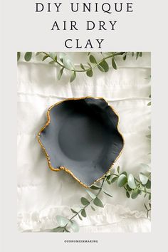 a black bowl with green leaves on it and the words diy unique air dry clay