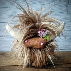 a stuffed animal with long hair and flowers on it's head