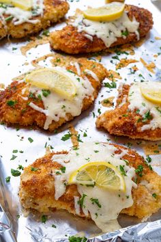 chicken schnitz with lemon and parmesan sauce on foil lined baking sheet