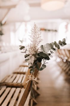 a bouquet of flowers sitting on top of a wooden bench in a room with white walls