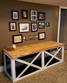 a large wooden table sitting in the middle of a room with pictures on the wall