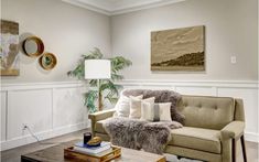 a living room filled with furniture and a painting on the wall above it's coffee table