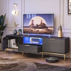 a flat screen tv sitting on top of a wooden entertainment center in a living room