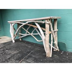 a wooden bench made out of branches against a blue wall