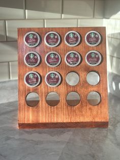 a wooden box with twelve different types of coffee pods in it on a marble counter top