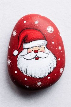 a painted rock with a santa clause on it