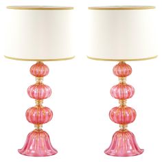 pair of pink glass lamps with gold trimmings and white shade on each lamp