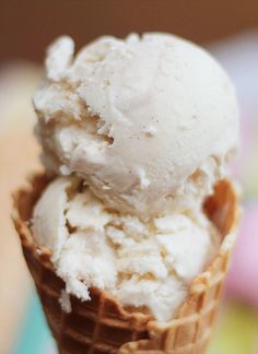 two scoops of ice cream sitting on top of each other in a waffle cone