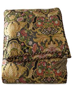 an image of a bed with a floral pattern on it and a tasseled pillow