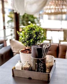 a potted plant sitting on top of a wooden tray filled with spices and utensils