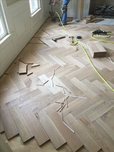 a man is working on wood flooring in a room that has been stripped off