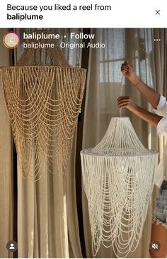 a woman standing in front of a chandelier with chains hanging from the ceiling