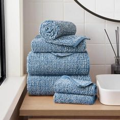 a stack of blue towels sitting on top of a wooden counter