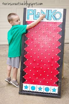 a young boy standing next to a giant sign that says plinko on it