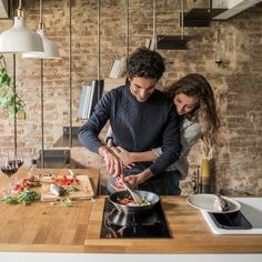 a man and woman are preparing food in the kitchen