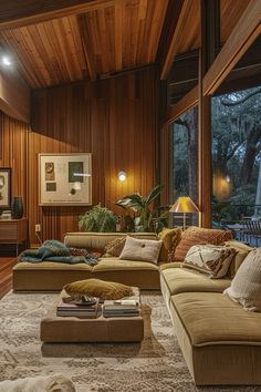 a living room filled with lots of furniture next to a wooden wall covered in windows